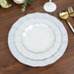Pearl white round dessert plates with gold edging, set on a wooden table.