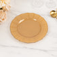 Gold heavy duty disposable dinner plate with ruffled rim on a marble surface.