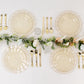 Gold glitter plastic dinner plates with ruffled rim on a table setting.
