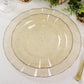 Gold glitter plastic dinner plate with ruffled rim on a table setting.