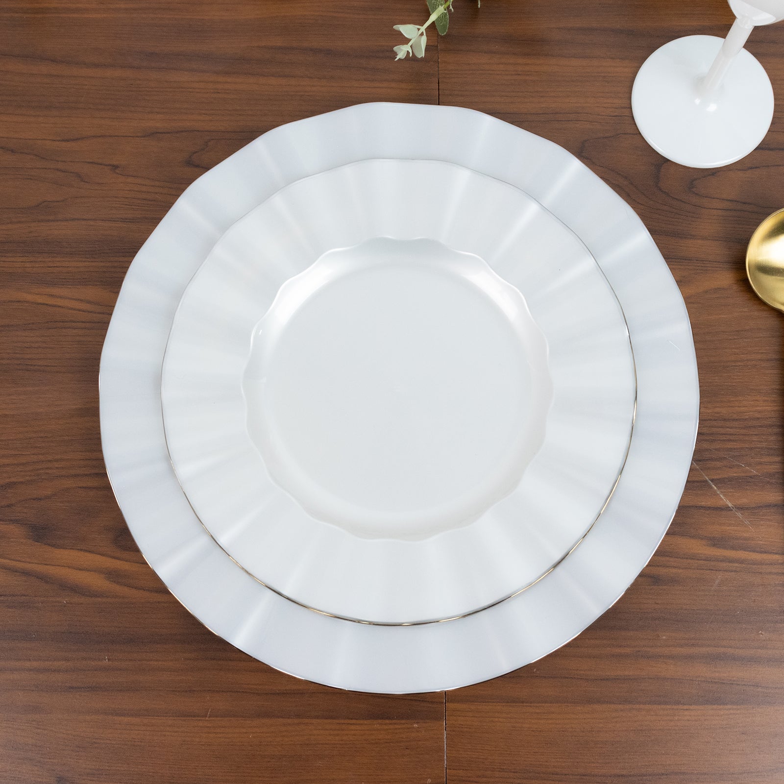 Pearl white ruffled rim dinner plates with gold edging, perfect for classy events.