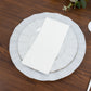 Pearl white ruffled rim dinner plate with gold edging on a wooden table.