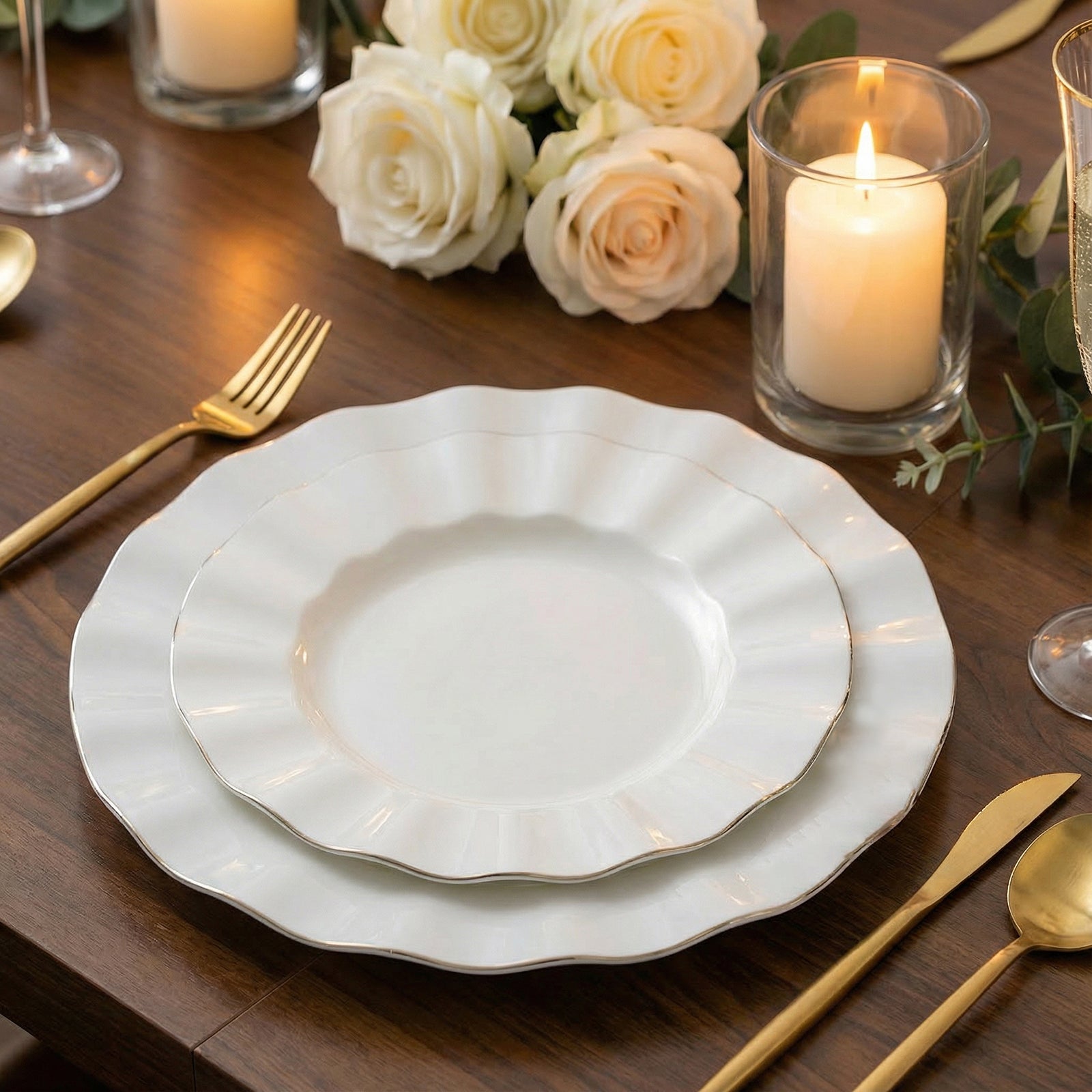 Pearl white ruffled rim dinner plates with gold edging on a table setting.