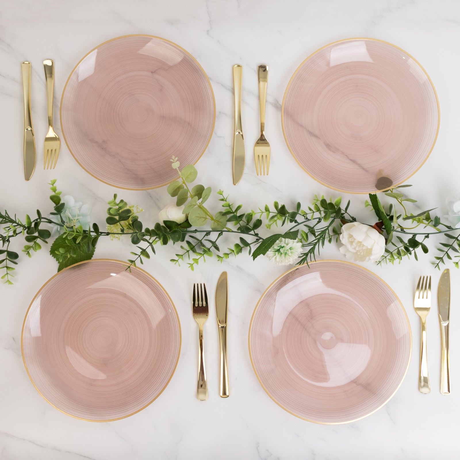 Dusty rose swirl plastic dinner plates with gold rim, elegant party table setting.