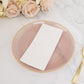 Transparent dusty rose swirl plate with gold rim on a marble surface.