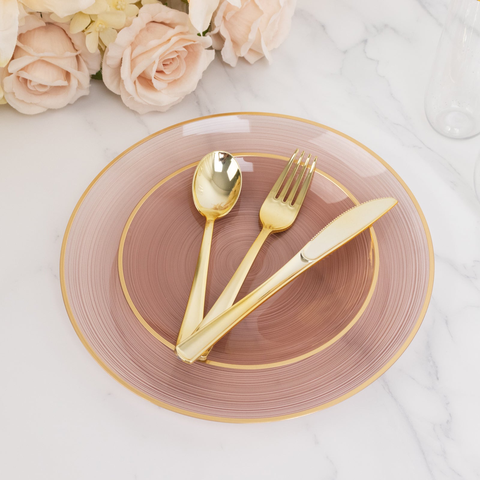 Dusty rose swirl plate with gold rim, elegant party table setting.