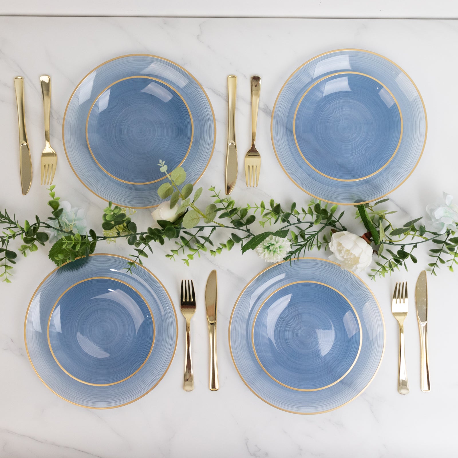 Dusty blue swirl salad dessert plates with gold rim on a marble surface.
