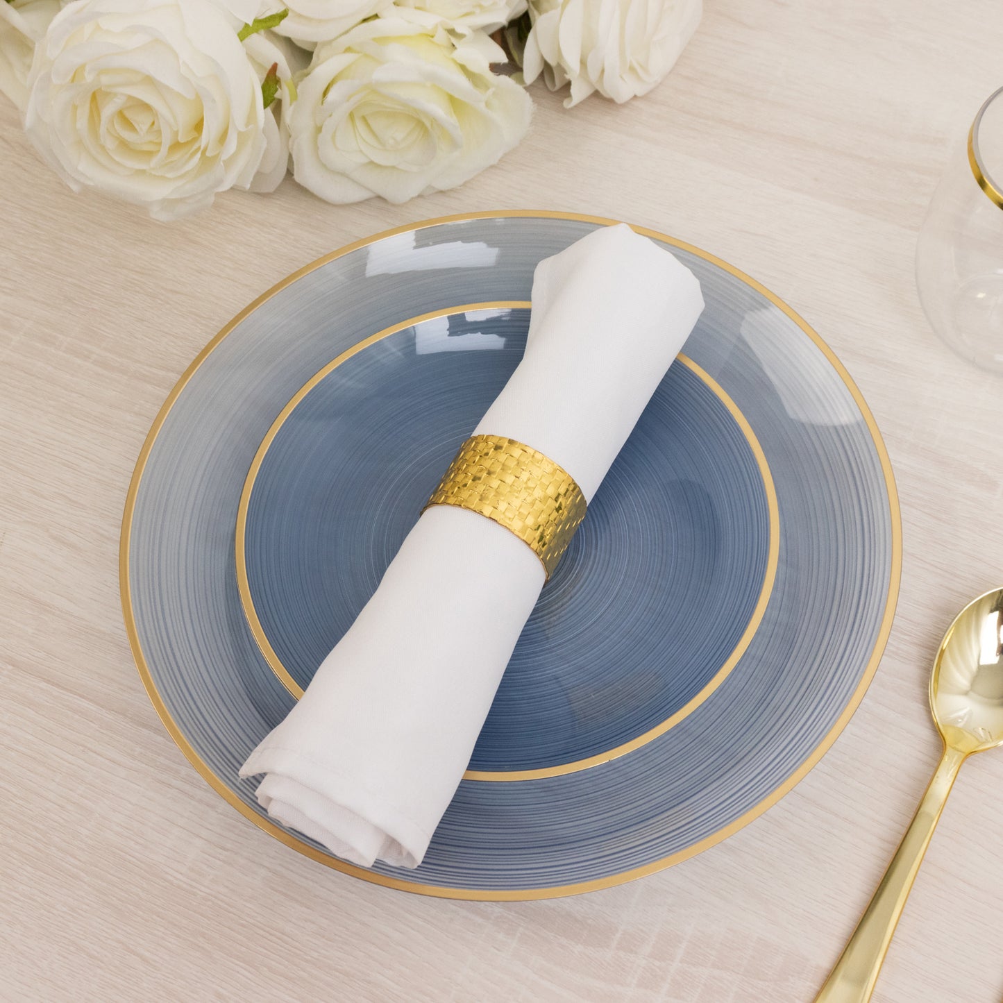 7" round transparent dusty blue swirl plate with gold rim and white napkin.