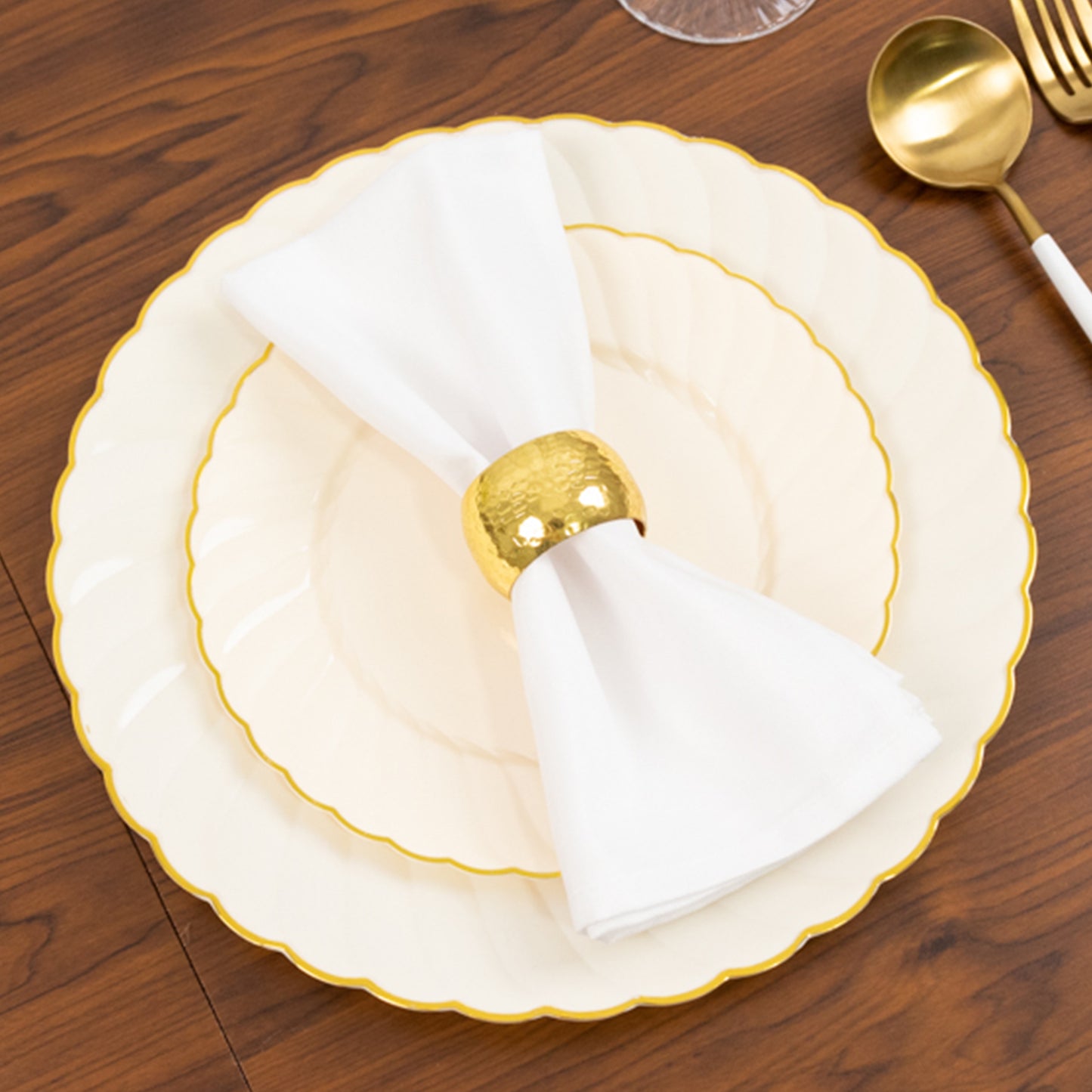 Ivory and gold flair rim disposable dessert plates on a wooden table.