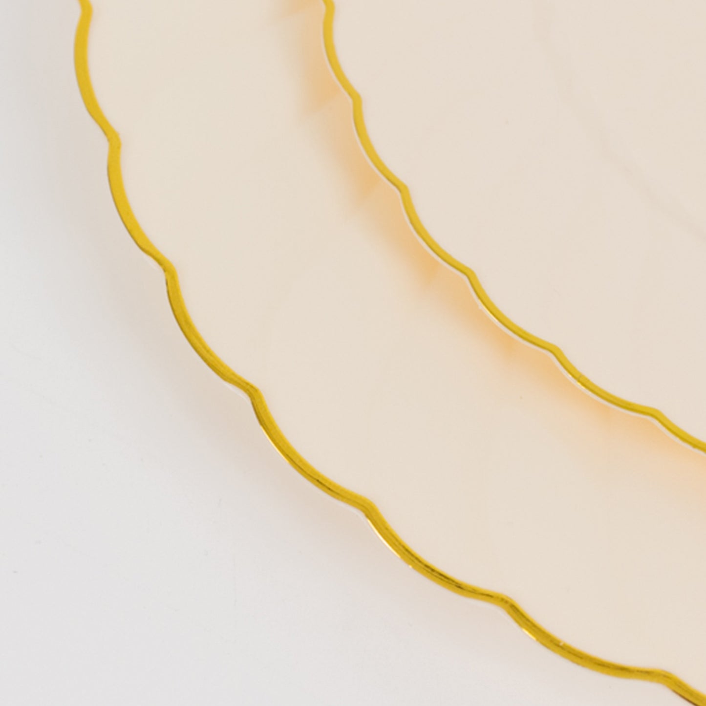 Ivory and gold flair rim disposable dessert plates stacked.