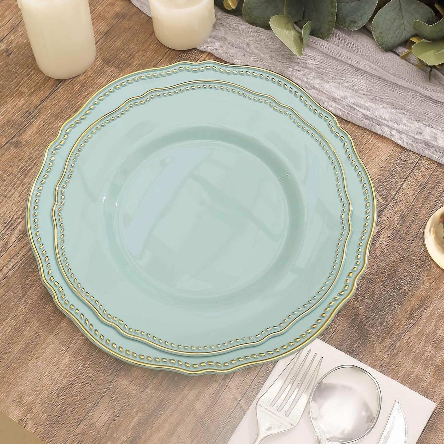 Elegant mint green plate with gold trim on a rustic wooden table setting. Perfect for dining.