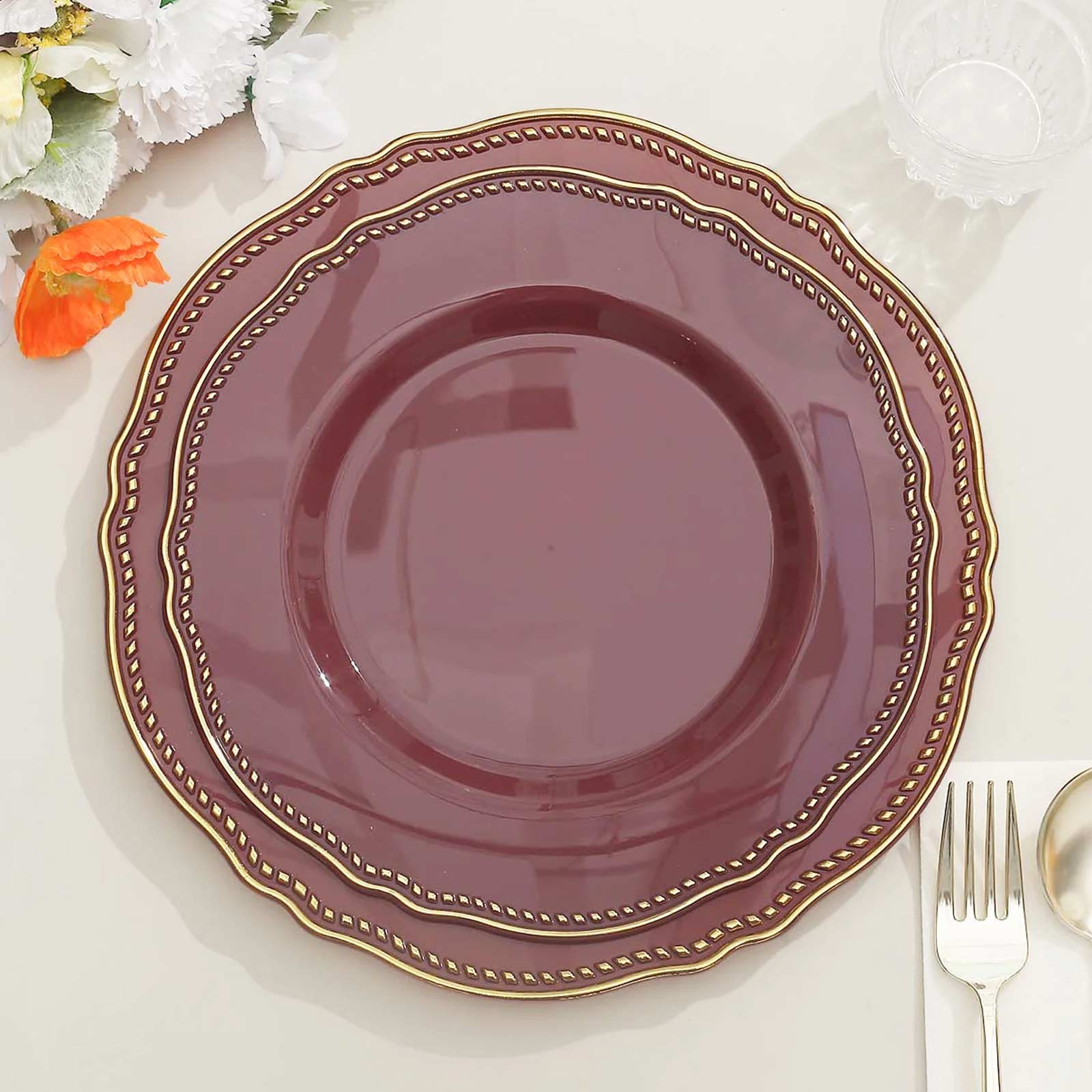 Elegant burgundy plate with gold trim, perfect for dining and decor.