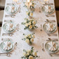 Sage green and white floral disposable salad plates on a dining table.