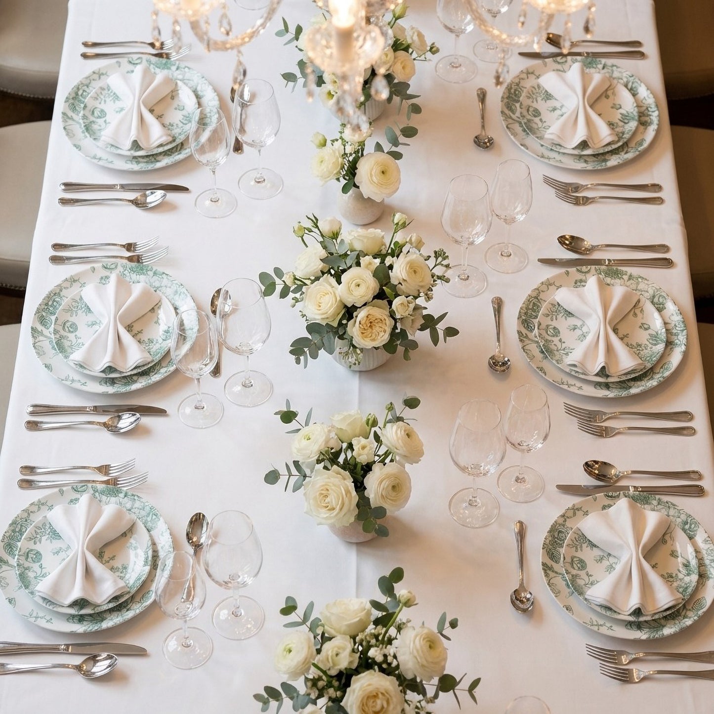 Sage green and white floral disposable salad plates on a dining table.