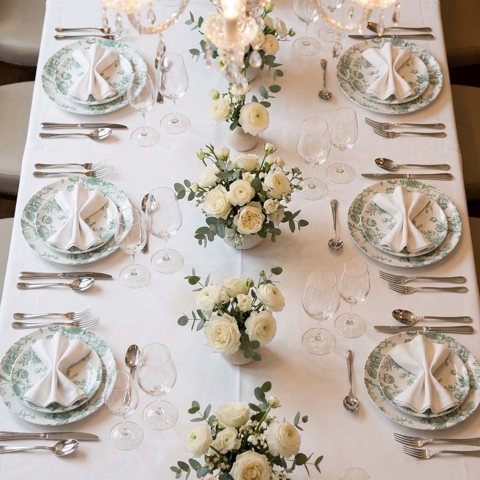 Sage green and white floral disposable salad plates on a dining table.