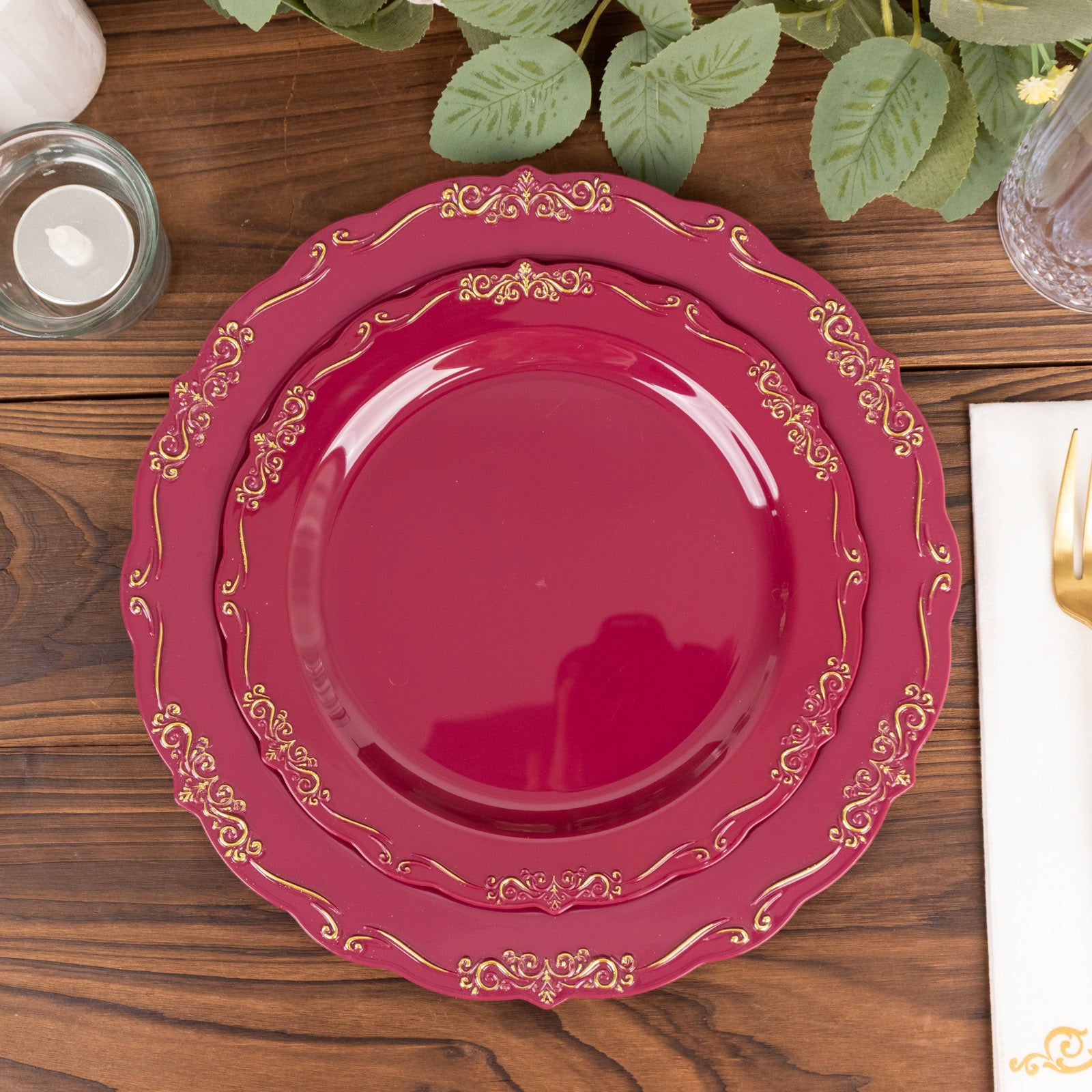 Burgundy disposable dinner plate with gold vintage rim and embossed scalloped edges.