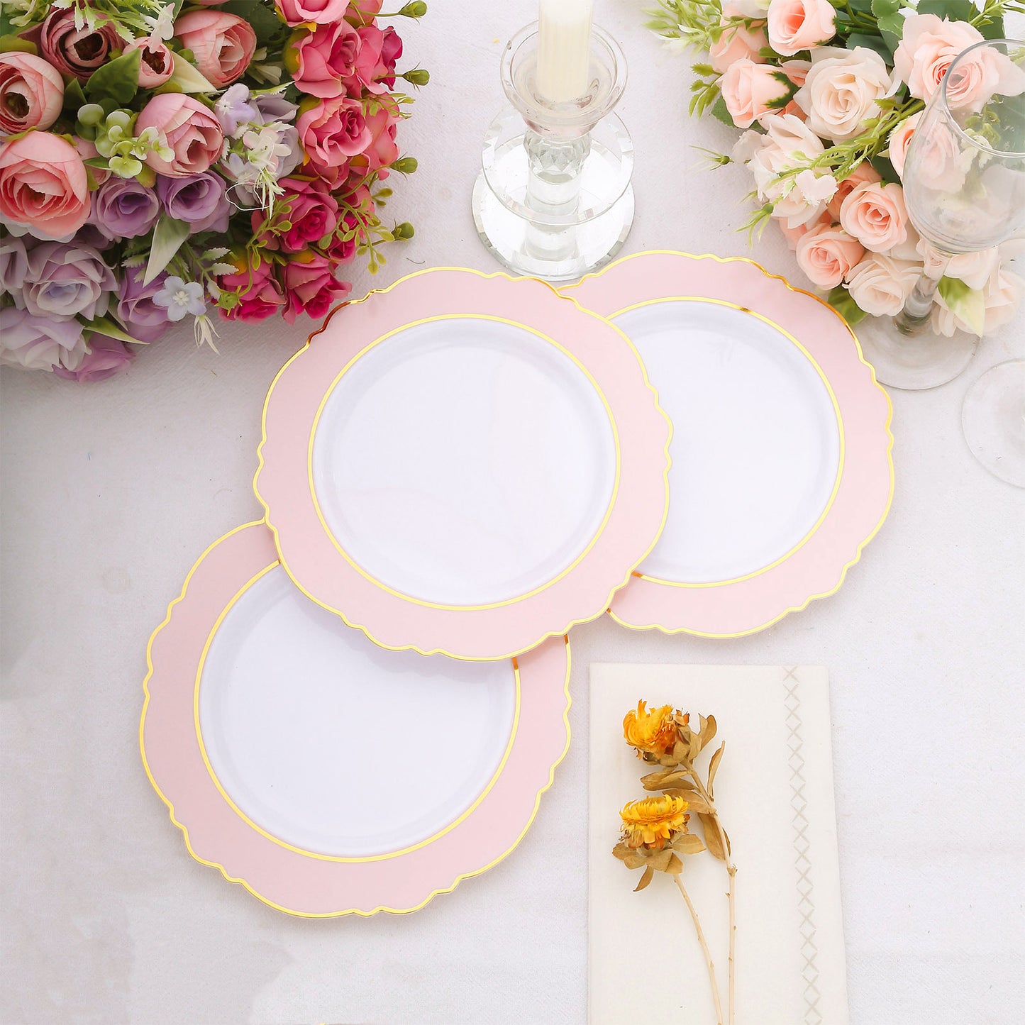 Blush white disposable plates with gold rim and round blossom design.