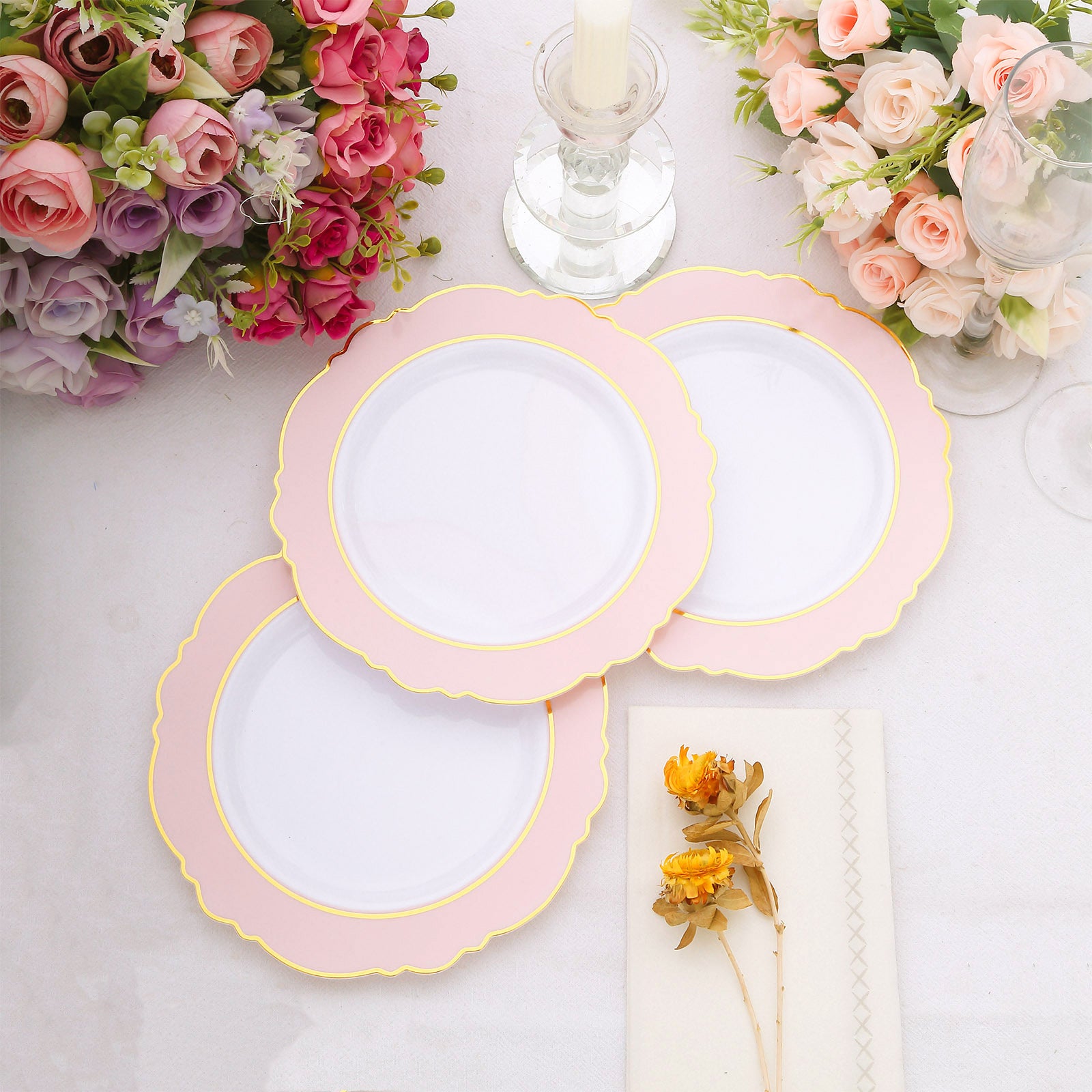 Blush white disposable plates with gold rim and round blossom design.
