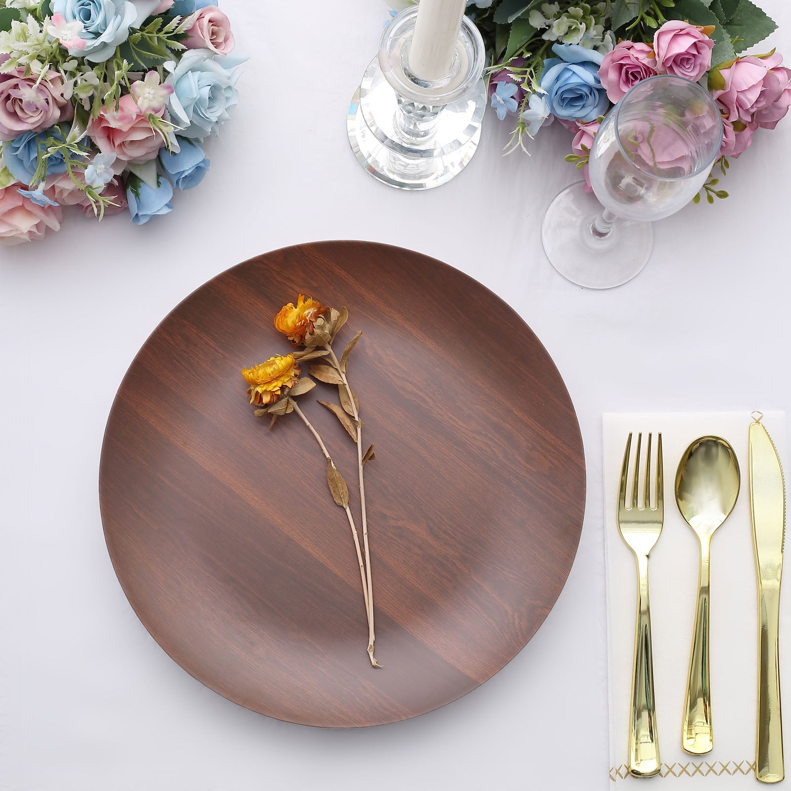 Rustic brown melamine dinner plate with a dried flower on a table setting.