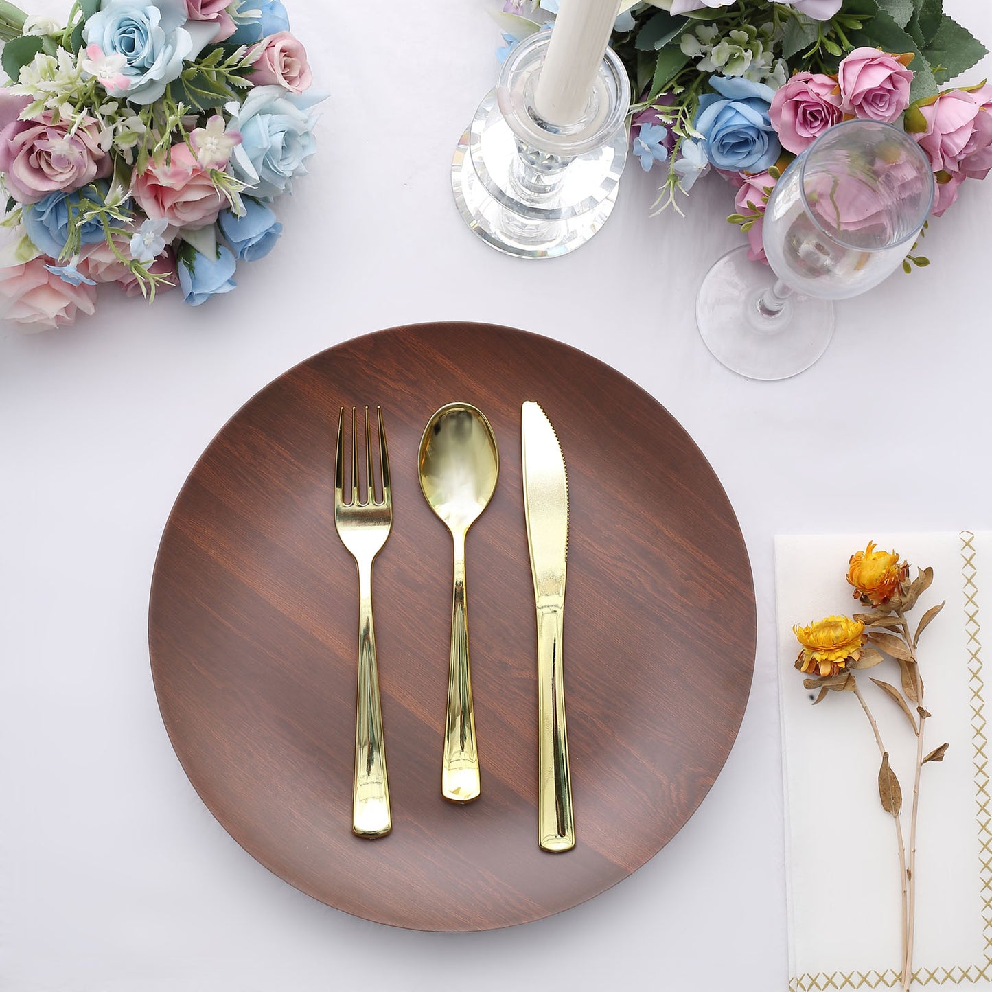 Rustic brown melamine dinner plate with gold utensils on a table setting.
