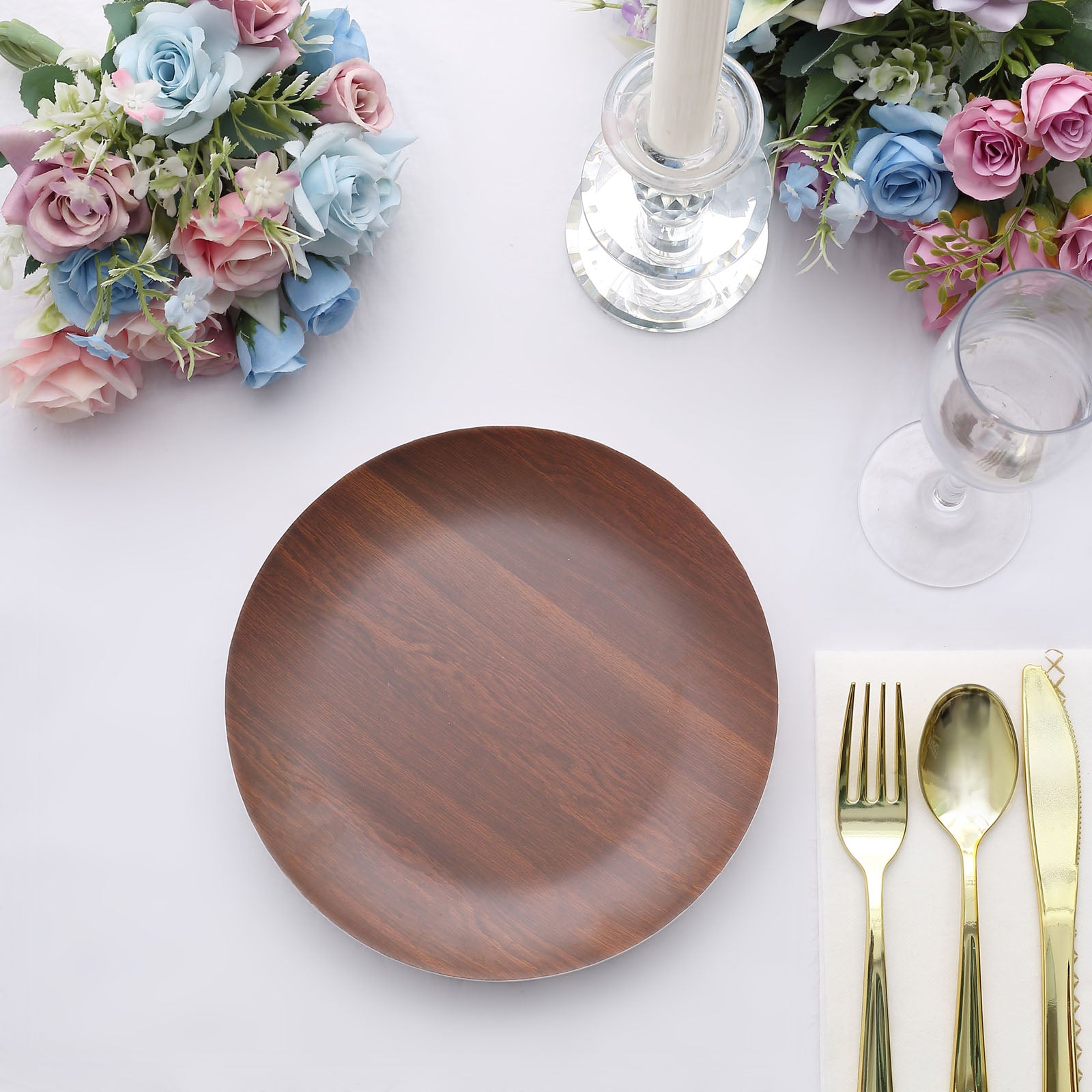 Rustic brown melamine salad plate on a table with floral arrangements.
