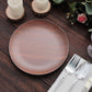 Rustic brown melamine salad plate with wood grain design on a rustic table setting.