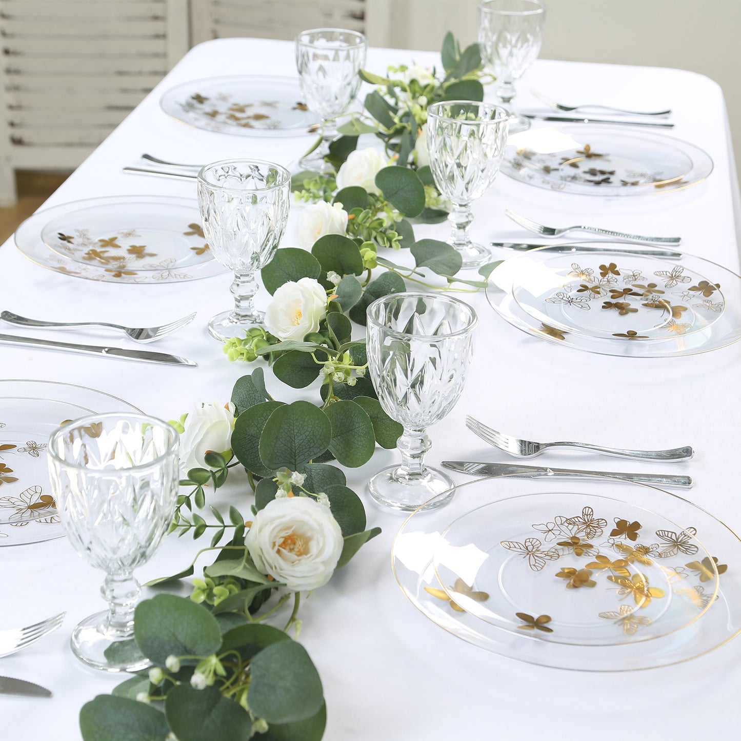 Clear gold butterfly plastic party plates with gold rim on a table setting.