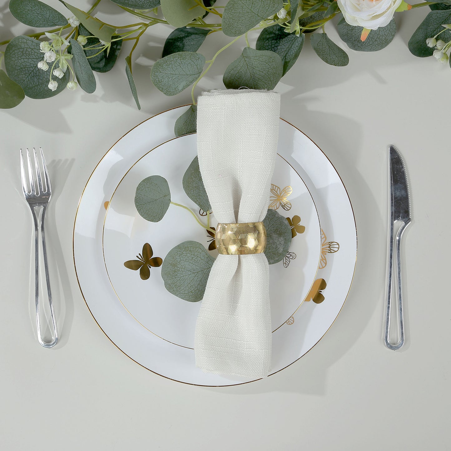 White gold butterfly disposable party plate with gold rim and greenery.