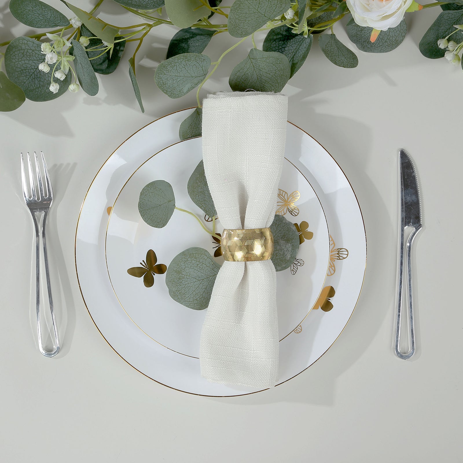 White gold butterfly disposable party plate with gold rim and greenery.