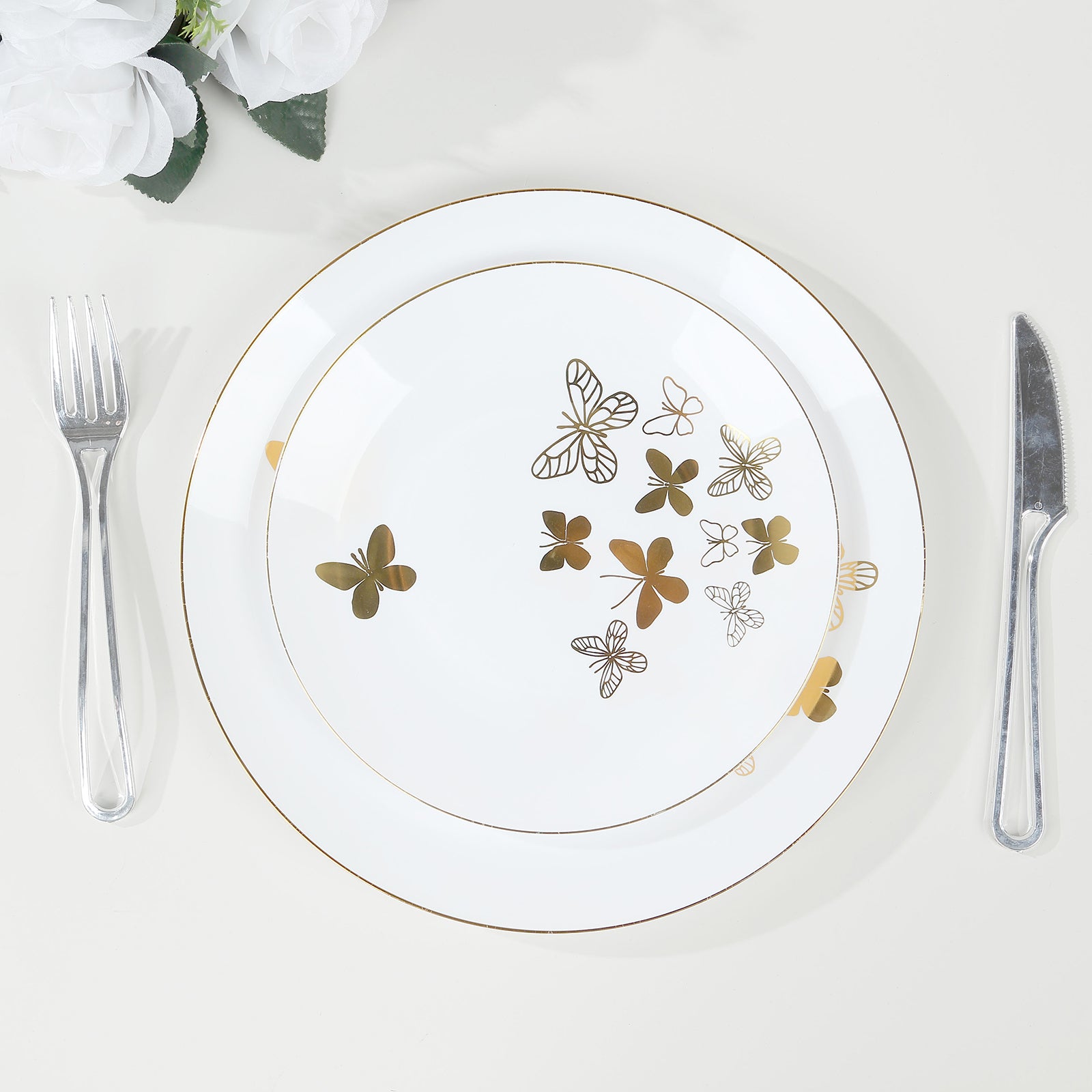 White gold butterfly plates with gold rim on a table setting.