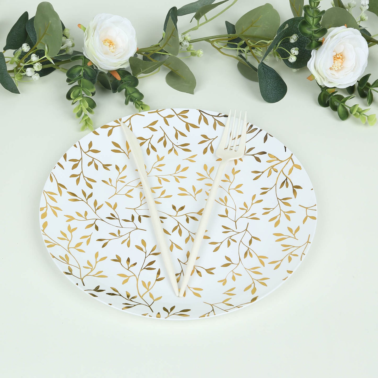 10" white round plastic party plate with gold leaf design, heavy duty disposable.