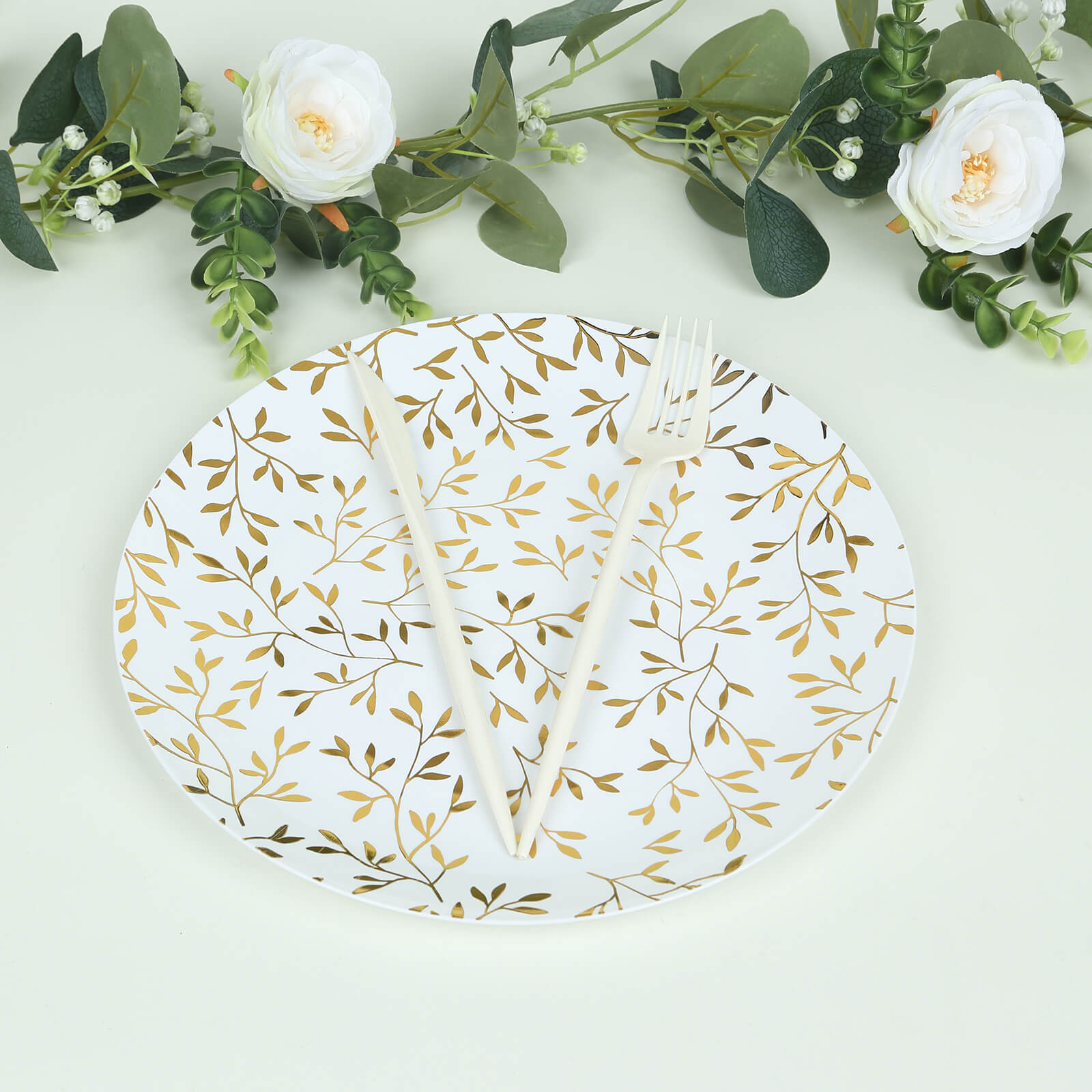 10" white round plastic party plate with gold leaf design, heavy duty disposable.