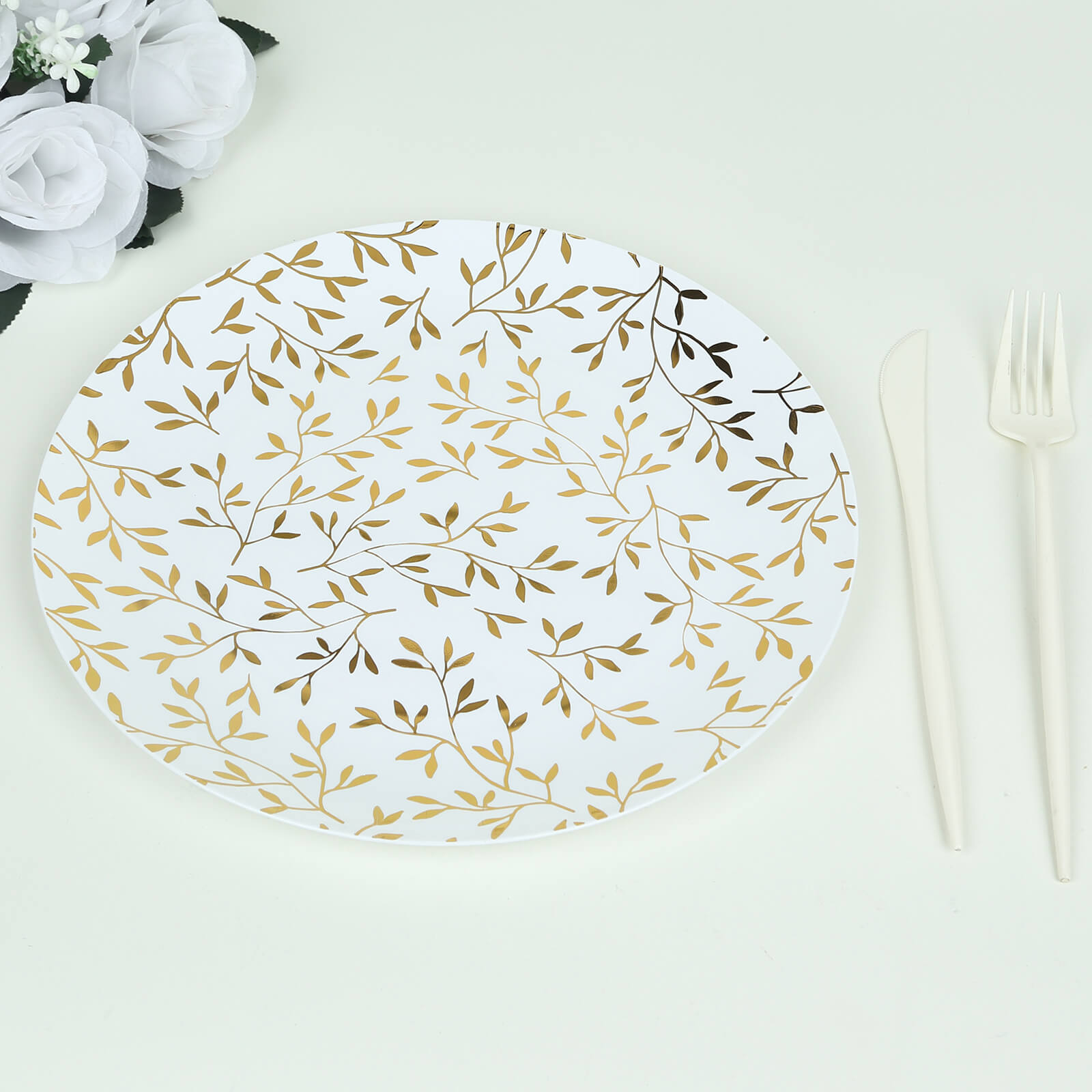 White round plastic party plate with gold leaf design.