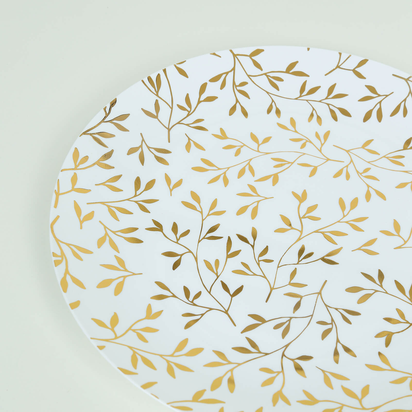 White round disposable dinner plate with gold leaf design.