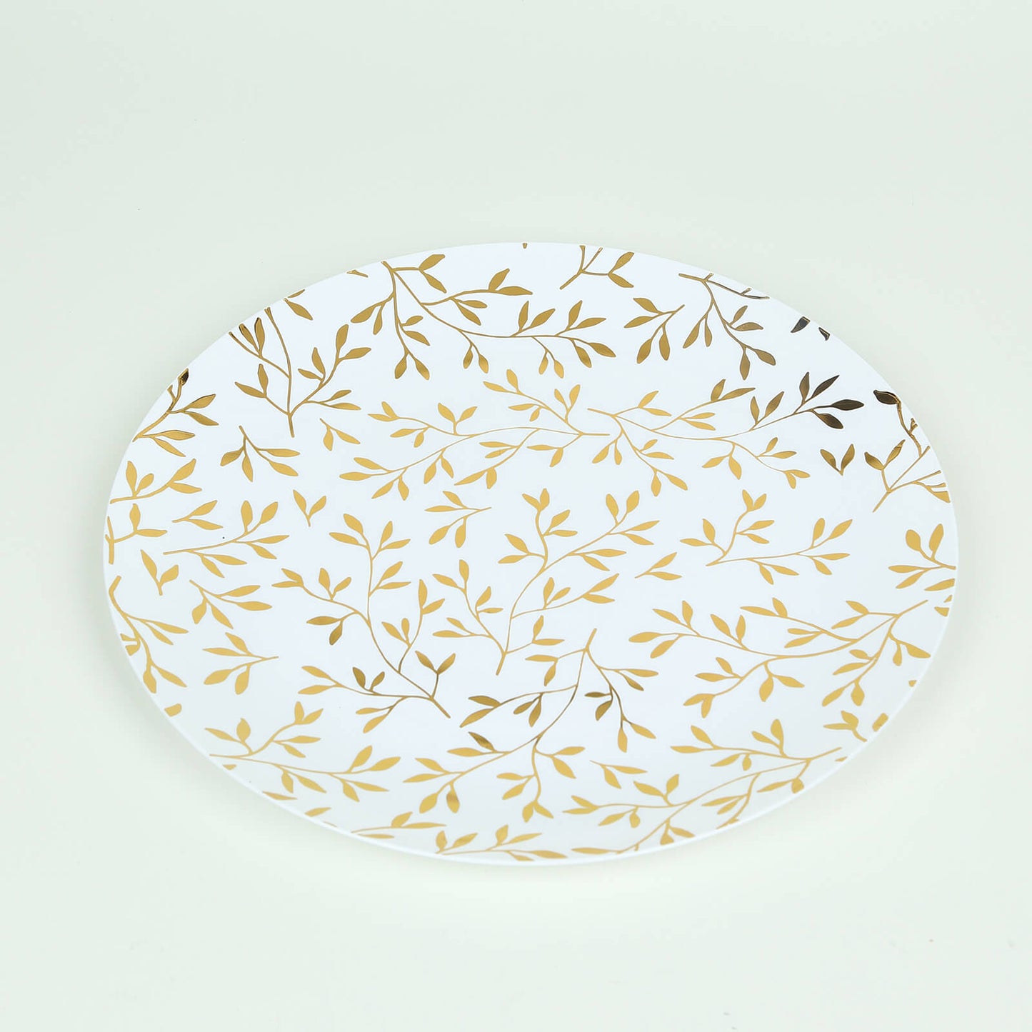 White round plastic party plate with gold leaf design.