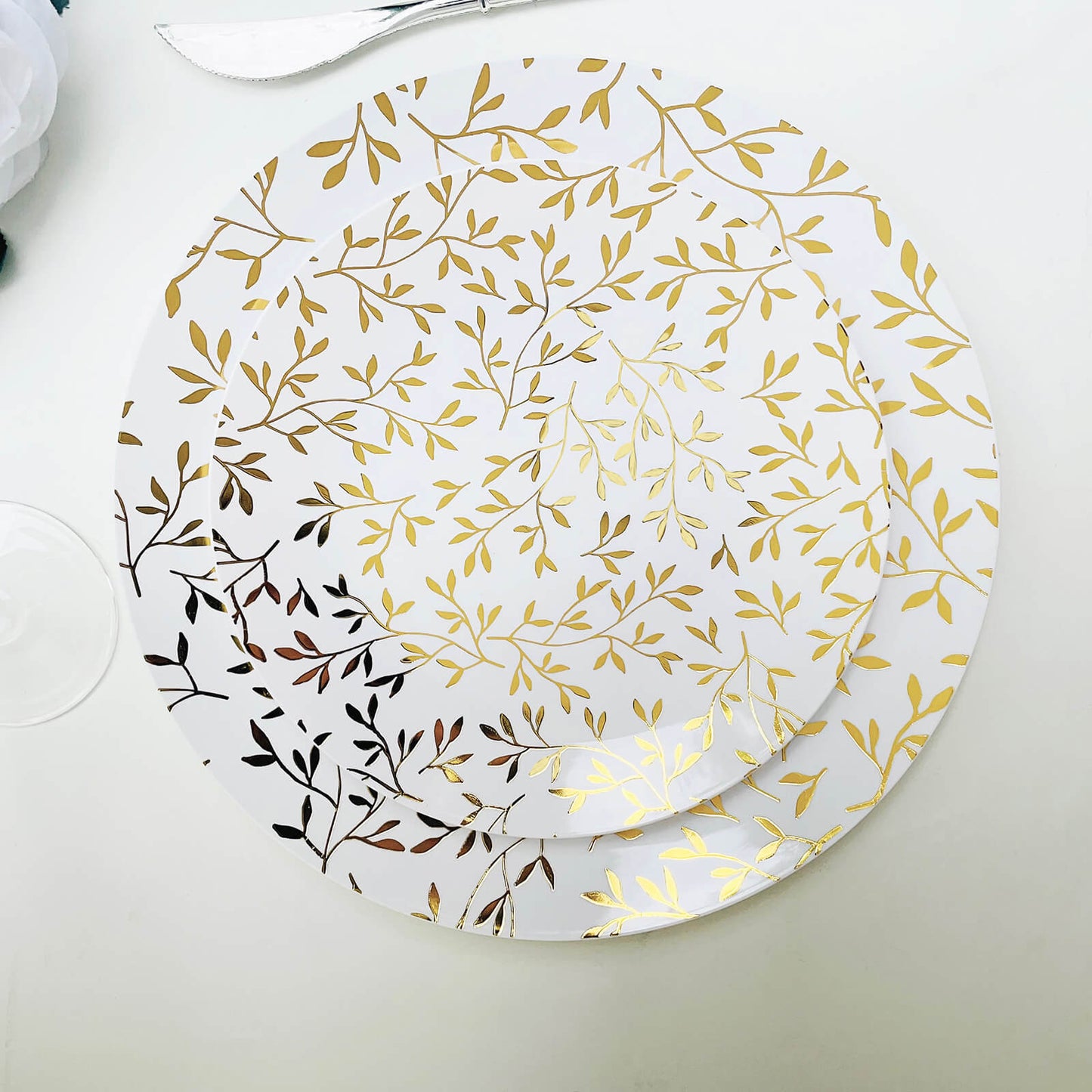 White round plastic party plates with gold leaf design.