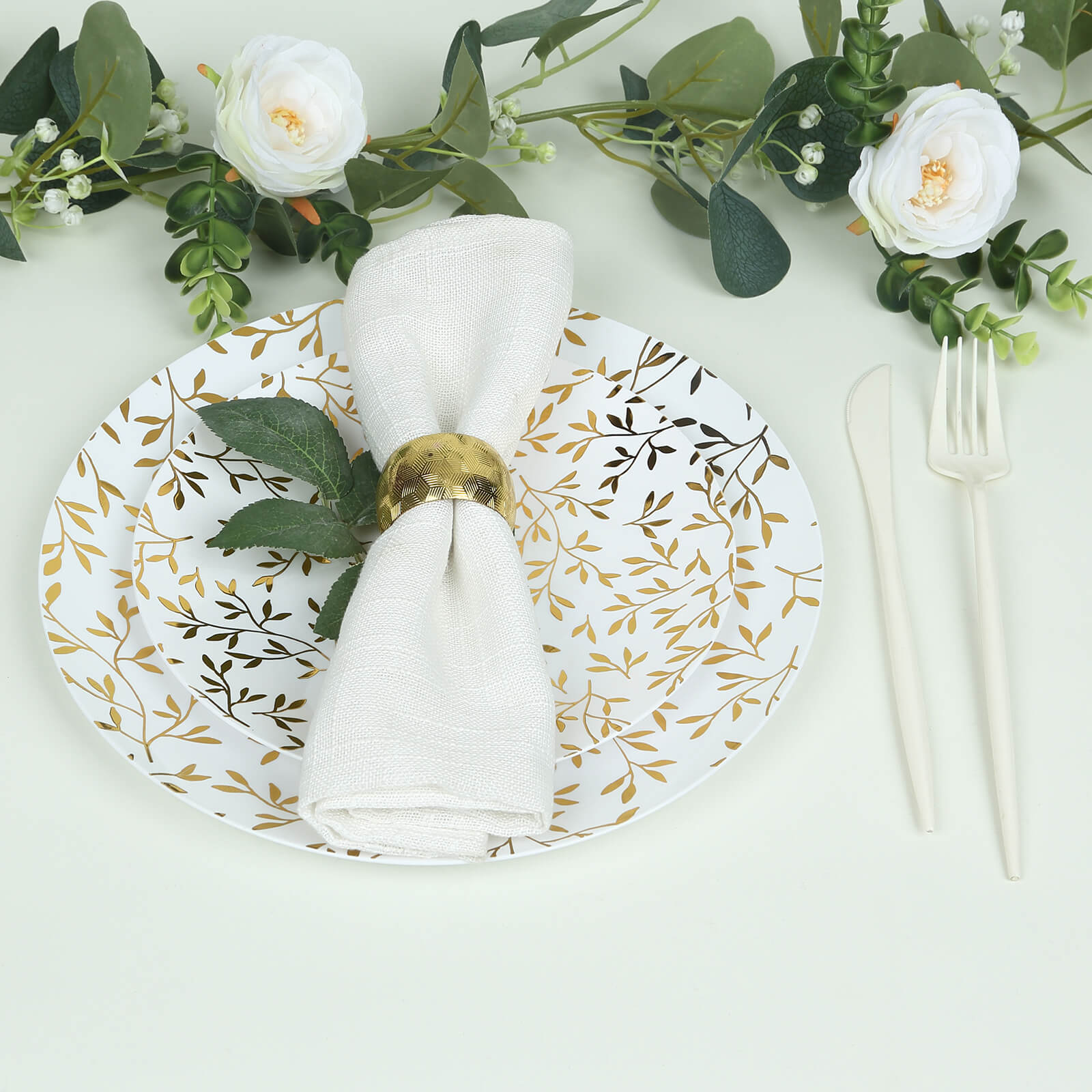 White round plastic party plate with gold leaf design, heavy duty disposable.