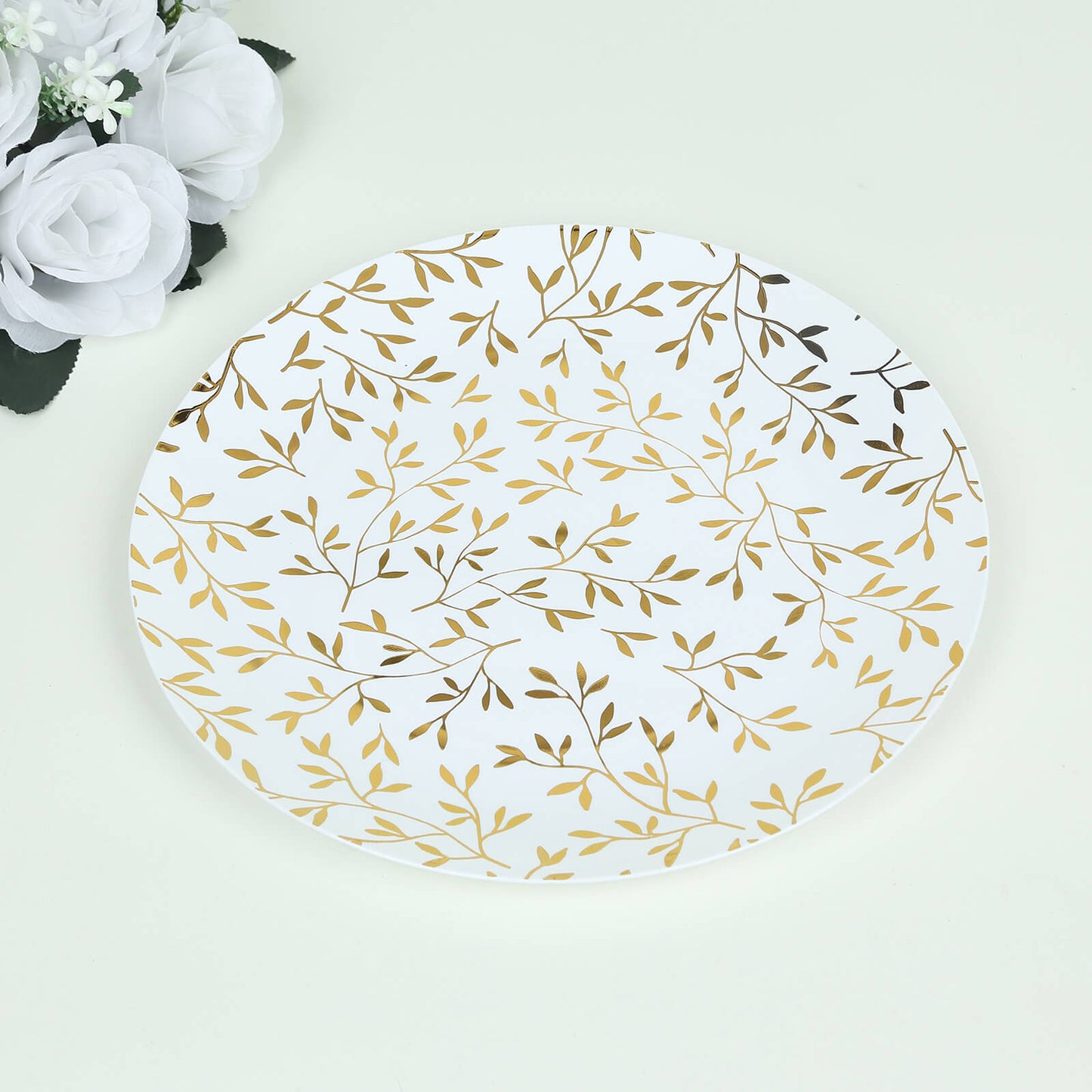 White round plastic party plate with gold leaf design.