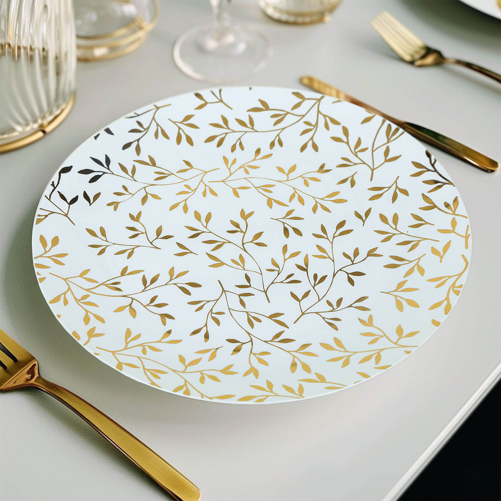 White round plastic party plate with gold leaf design.