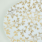 White round plastic dessert plate with gold leaf design.