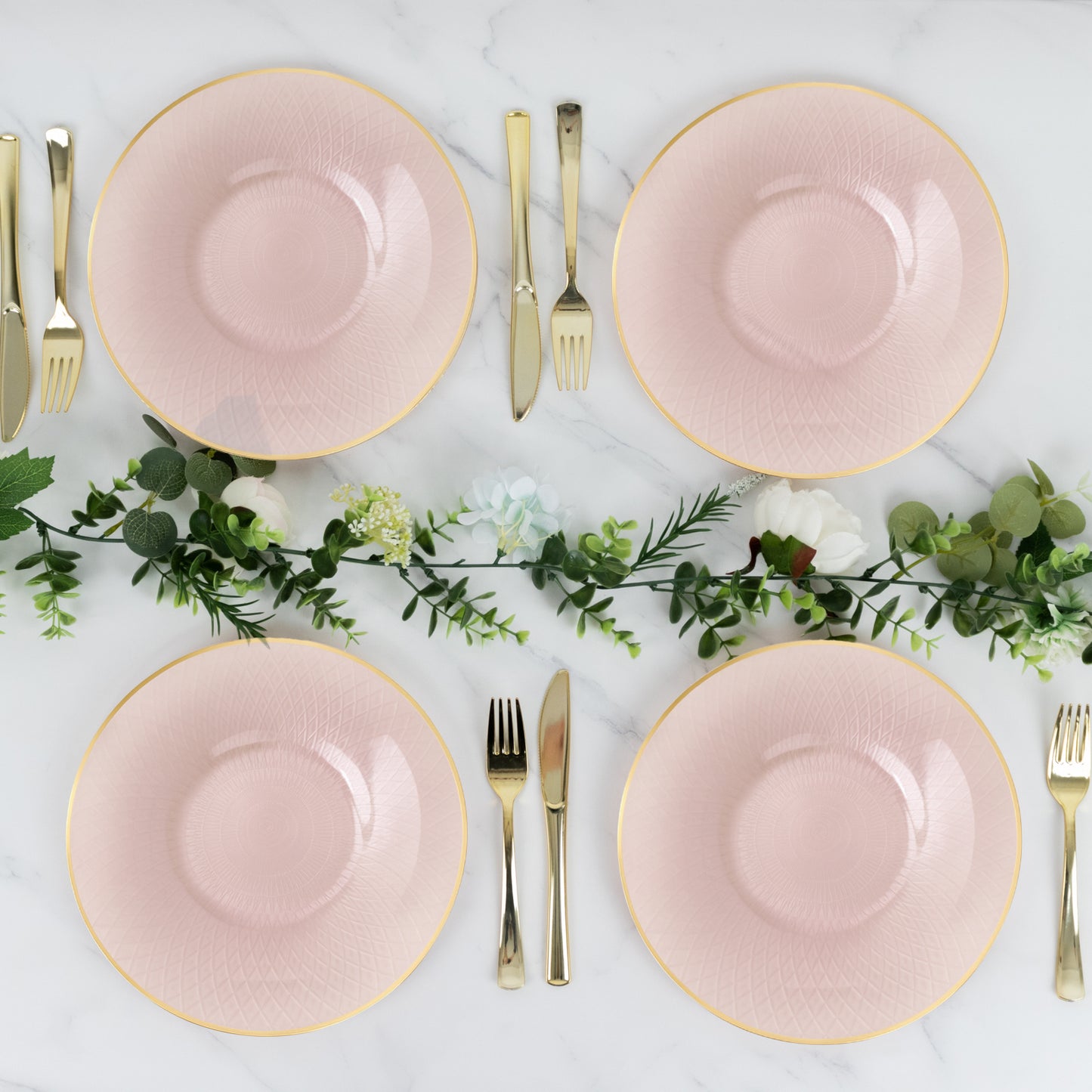 Blush pink dinner plates with gold rim and diamond-cut pattern, set for a party.