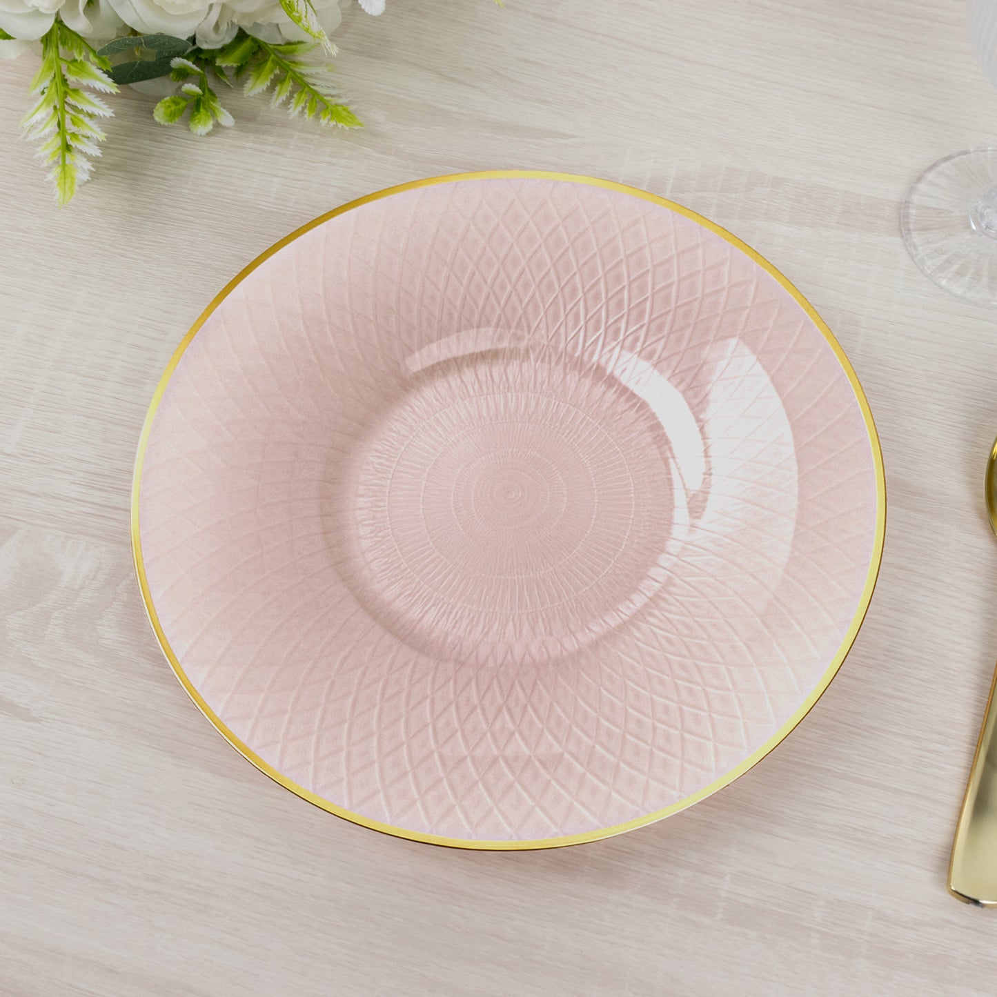 Blush pink round dinner plate with gold rim and radial diamond-cut pattern.