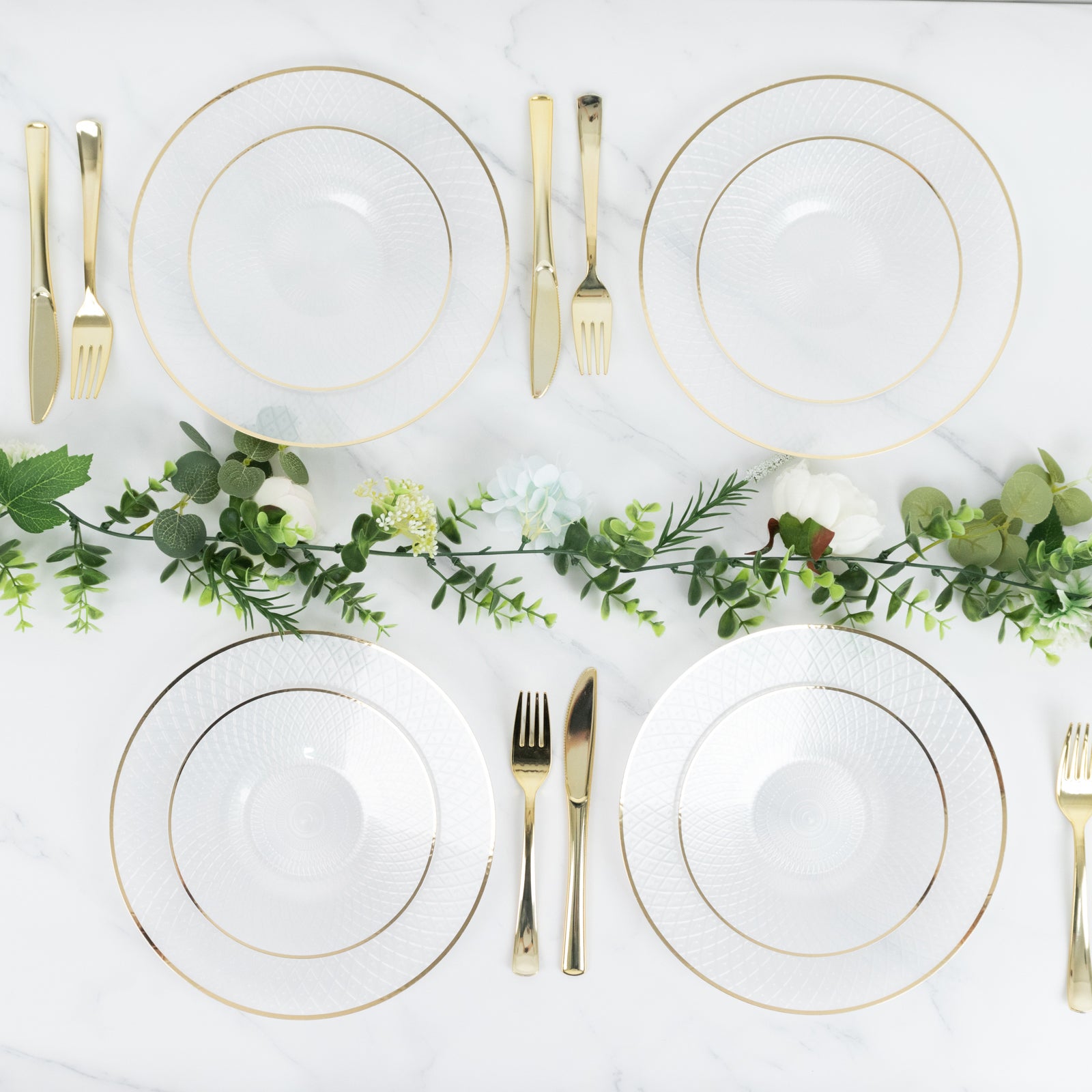 Round pearl white disposable dessert plates with gold rim on a table setting.