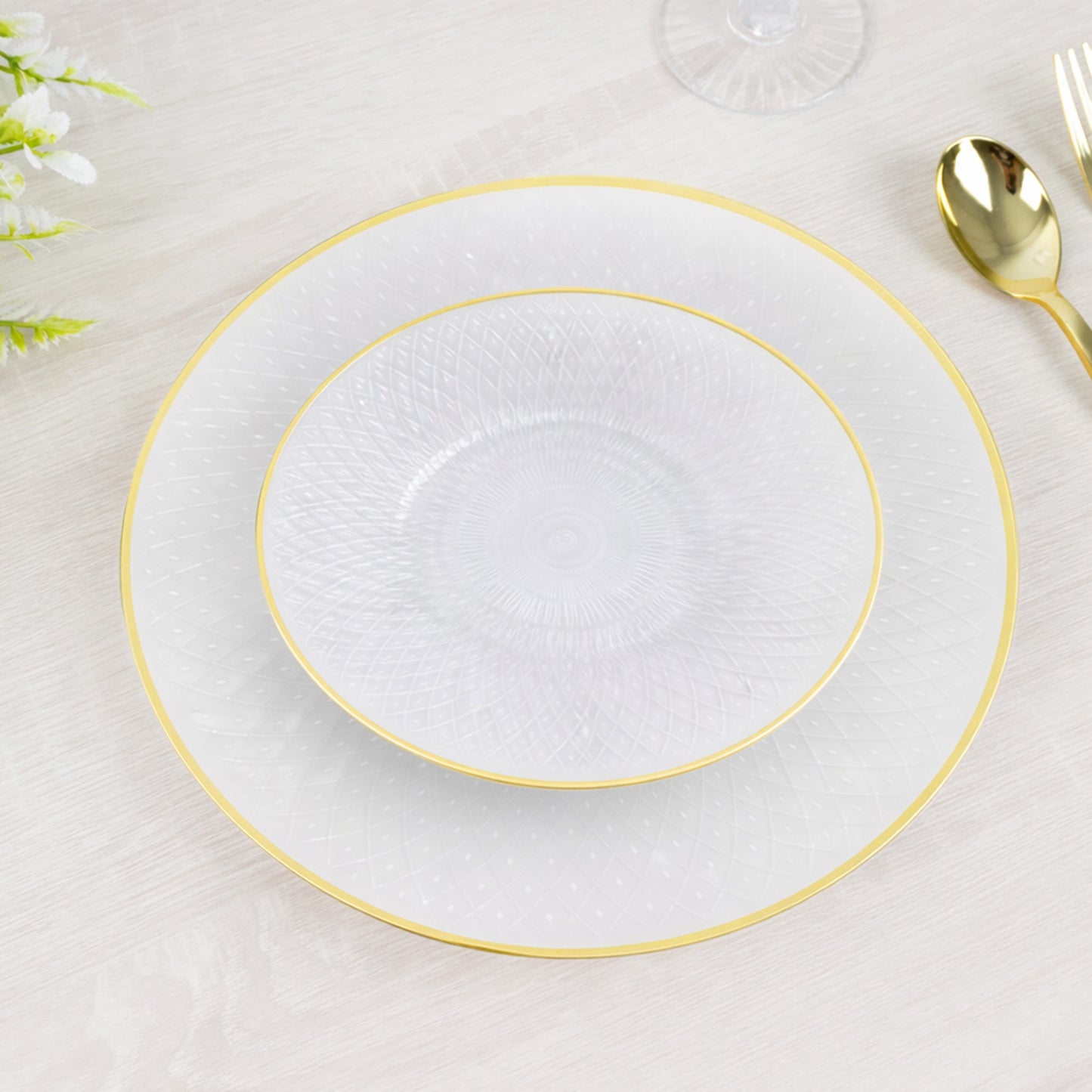 Round pearl white disposable plates with gold rim and diamond-cut pattern.