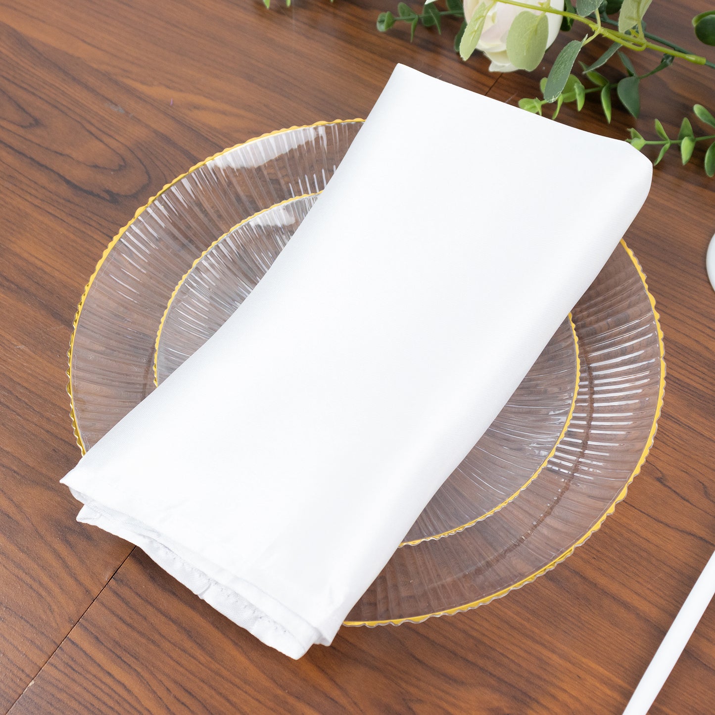 Clear plastic dinner plate with gold rim and ribbed sunburst pattern.