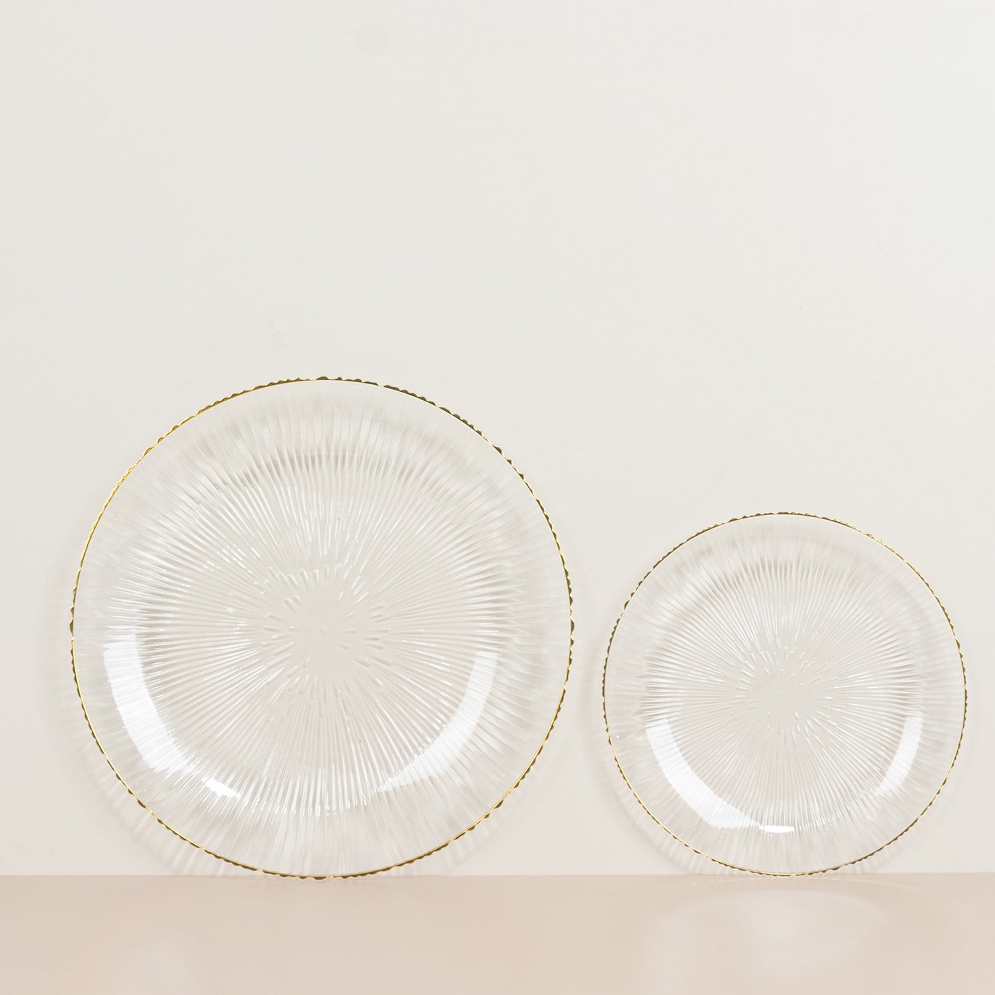 Clear plastic dessert plates with gold rim and ribbed sunburst pattern.