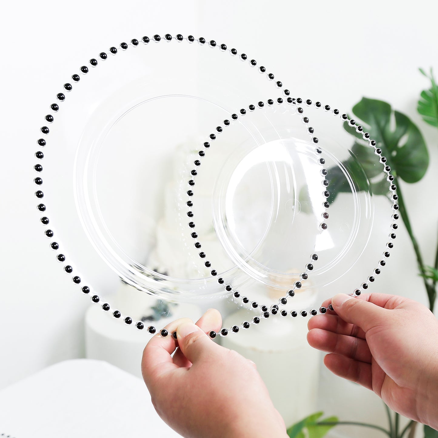 Clear plastic dinner plates with black beaded rim, perfect for parties.