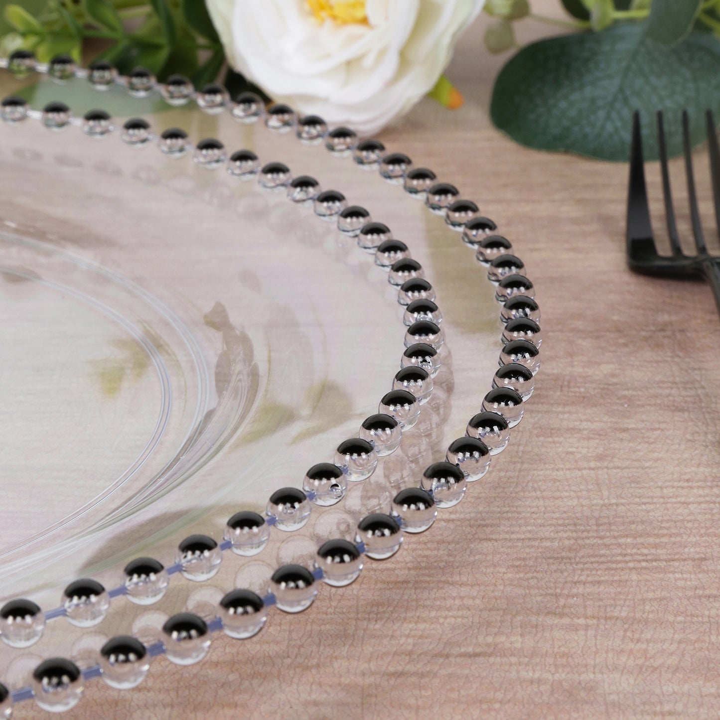 Clear plastic dinner plate with black beaded rim, ideal for parties and banquets.