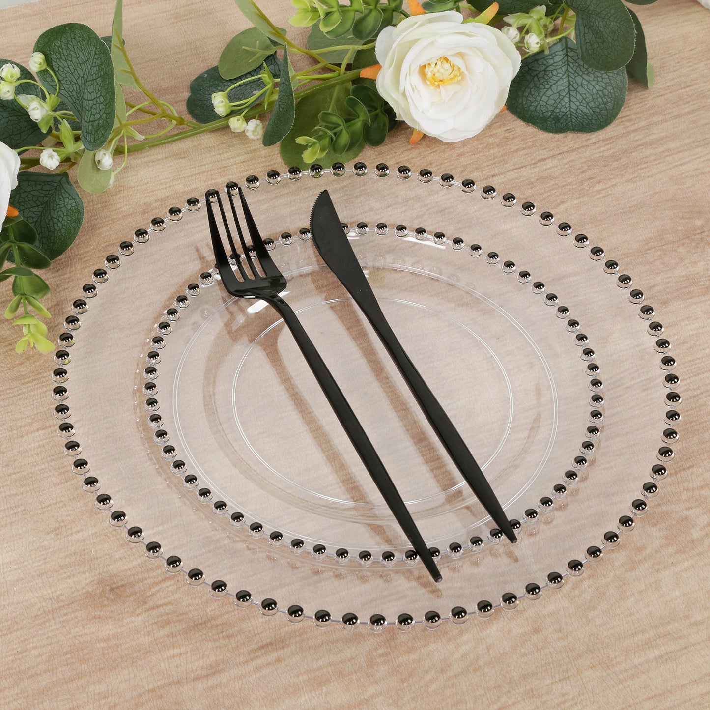 Clear plastic dessert plate with black beaded rim, disposable for events.