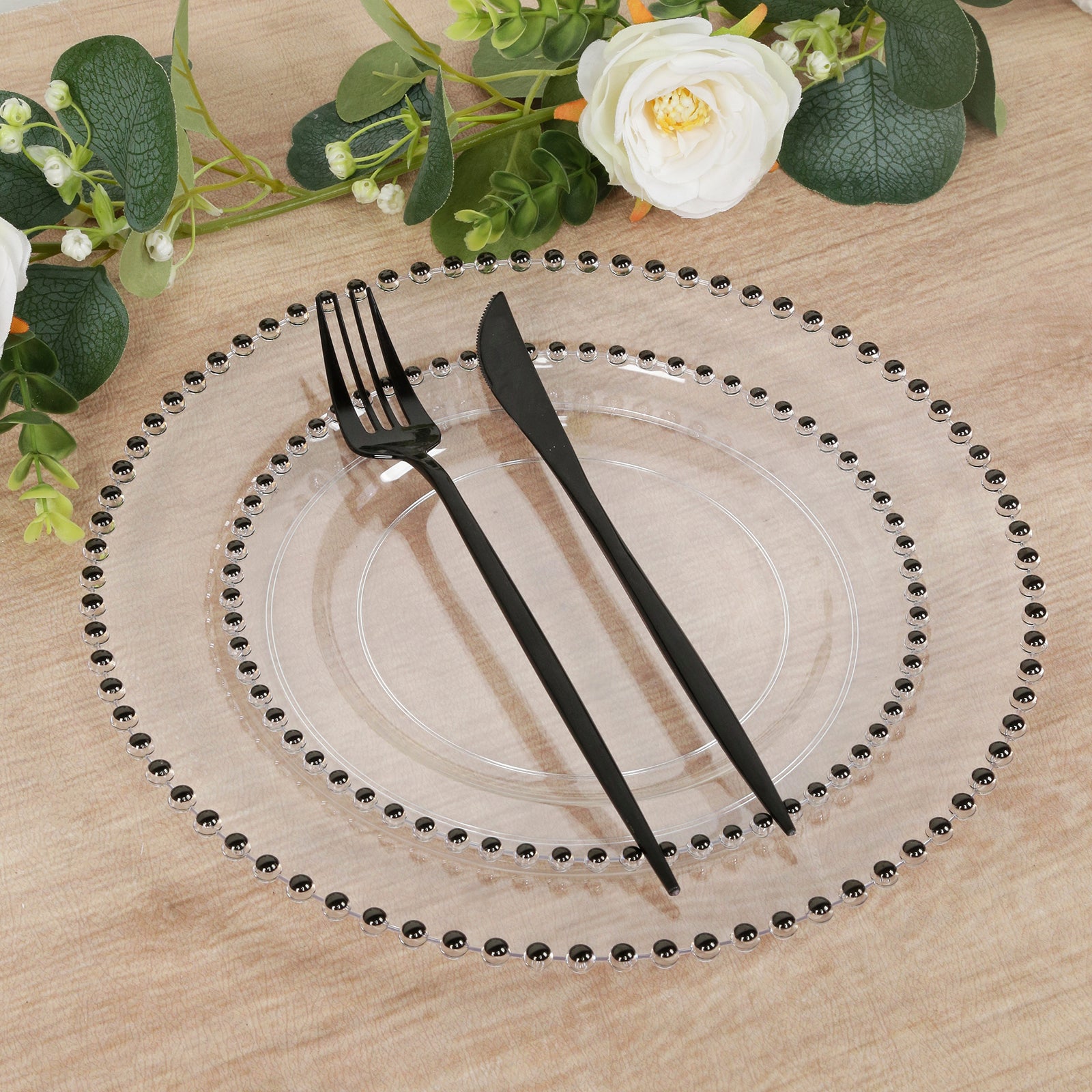 Clear plastic dessert plate with black beaded rim, disposable for events.
